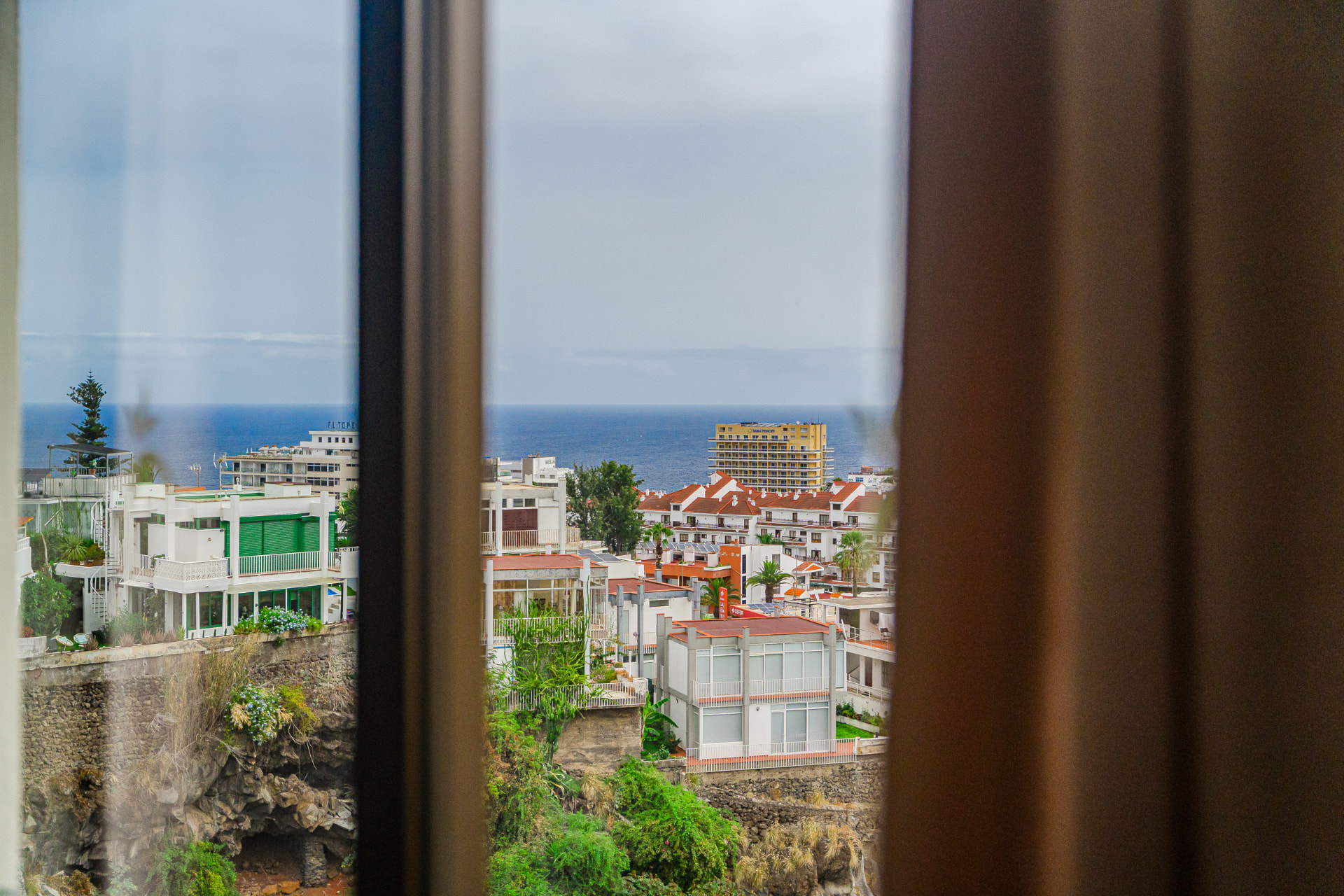 Blick aus dem Fenster über die Dächer auf den Atlantik